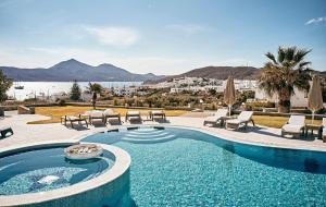 una piscina con sillas y vistas al agua en Santa Maria Luxury Suites & Spa, en Adamas