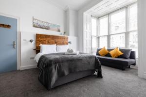 a bedroom with a large bed and a couch at Seascape in Penzance