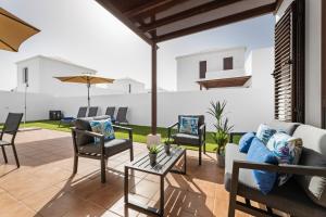 patio z krzesłami, kanapą i stołem w obiekcie Lanzarote Villa Arts w mieście Playa Blanca