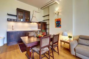 een keuken en een woonkamer met een tafel en een bank bij Ilo Apartamentai in Vilnius