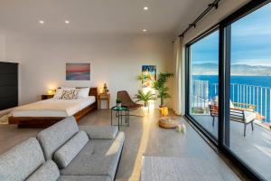 a living room with a bed and a large window at Born in Blue in Kaş