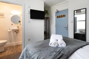 - une chambre avec un lit et des serviettes dans l'établissement Seascape, à Penzance