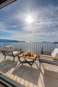 a balcony with two chairs and a table and a view of the water at Born in Blue in Kaş