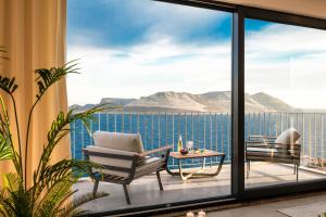 a balcony with a view of the ocean and mountains at Born in Blue in Kaş