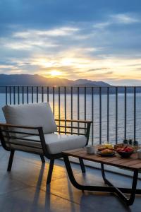 a chair and a table on a balcony with the ocean at Born in Blue in Kaş