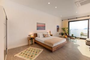 a bedroom with a bed and a large window at Born in Blue in Kaş