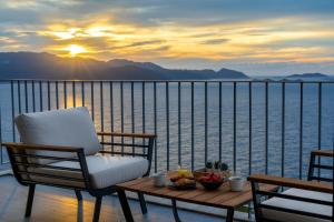a chair and table on a balcony with a view of the water at Born in Blue in Kaş