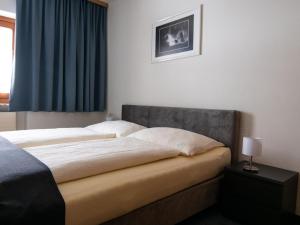 ザールバッハ・ヒンターグレムにあるLandhaus Zehentnerのベッドルーム1室(青いカーテン付きの大型ベッド1台付)