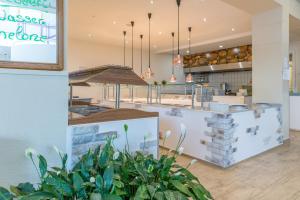 a restaurant with a counter with plants in the foreground at Familienhotel Reiterhof Runding in Runding