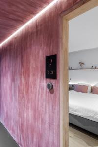 a clock on a wall next to a bed at Poutrelle Guestrooms in Bruges