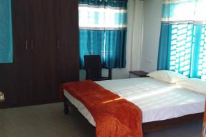 Un dormitorio con una cama grande con cortinas azules. en DWARAKA STAY INN-Rejoicing Family Home Coorg, en Kushālnagar