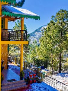 einen Pavillon mit Schnee auf dem Boden und Bäumen in der Unterkunft THEHIMALAYANLIVING WHISTLING PINES in Mukteswar