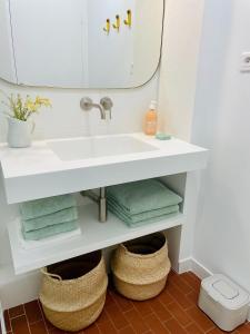 ein Bad mit einem Waschbecken, Handtüchern und einem Spiegel in der Unterkunft Superbe T3 dans les pins, terrasse sud, petite vue mer, plage à pieds, garage privé gratuit in Les Lecques