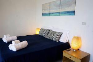 um quarto com uma cama azul com toalhas em Comfort in riva al mare em Belmonte Calabro