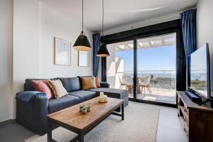 een woonkamer met een bank, een tv en een tafel bij Blue Sunset Penthouse in Castillo de Sabinillas