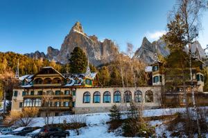 une grande maison en face d'une montagne dans l'établissement Hotel Salegg, à Alpe di Siusi