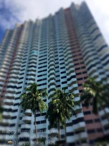 um edifício alto com palmeiras em frente em Happy Home 26 Sri Sayang Batu Ferringhi em Batu Ferringhi