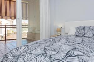 a bedroom with a black and white bed with a balcony at La Casa de Bebita in Fuengirola