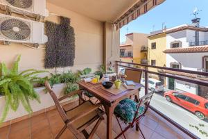 balcón con mesa y sillas de madera en La Casa de Bebita en Fuengirola