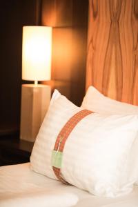 a pillow sitting on top of a bed with a lamp at Holiday Inn - Salzburg City, an IHG Hotel in Salzburg