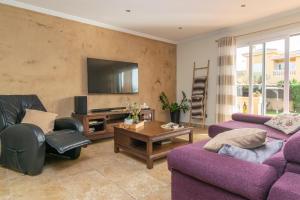 a living room with two purple couches and a tv at Joan Deia Escultor in Marratxí 