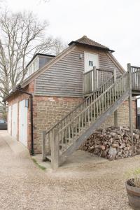 ein Backsteingebäude mit einer Holztreppe davor in der Unterkunft The Countryside Annexe in Pulborough