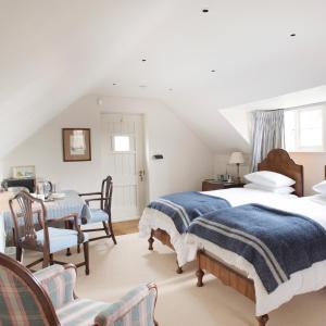 1 dormitorio con 2 camas, mesa y sillas en The Countryside Annexe, en Pulborough