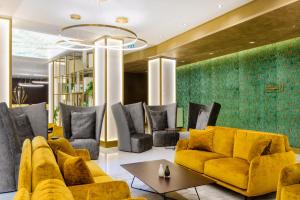 a living room with a yellow couch and chairs at Emerald Downtown Luxury Suites by Continental Group in Budapest +103 photos
