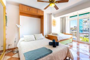 a bedroom with two beds and a ceiling fan at Sunny Seaside Apartment in Arroyo de la Miel +16 photos