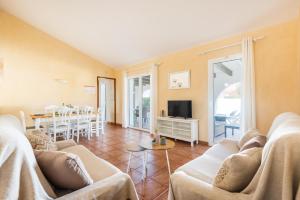 un soggiorno con 2 divani e una sala da pranzo di Villa Androna a Cala'n Bosch