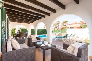 an outdoor patio with wicker furniture and a swimming pool at Villa Androna in Cala'n Bosch