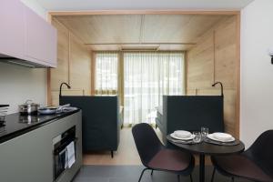 uma cozinha com mesa e cadeiras num quarto em Townhouse N9 em St. Moritz