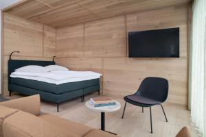 a bedroom with a bed and a tv and a couch at Townhouse N9 in St. Moritz