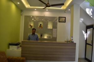 a man standing behind the counter of a salon at Tapasthali by Meera Hotels in Rishīkesh