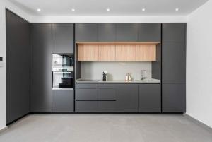 a kitchen with black cabinets and a sink and an oven at Quesada sun rojales in Rojales