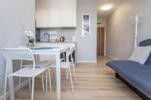 cocina y sala de estar con mesa y sillas en Urban Jungle - Grey Apartment, en Białystok
