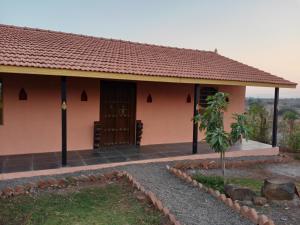 a small house with a red roof at Mohole Wada, Ramshej Fort, Nashik in Gangāpur