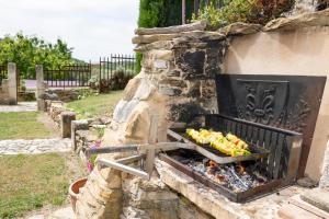 a stone fireplace with food cooking on it at Fontdecounet in Lardiers