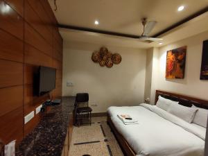 a hotel room with a bed and a television at Stay @ 203 in Noida