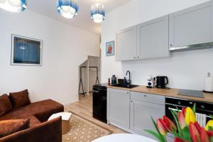 una cucina e un soggiorno con armadi bianchi e divano di #stayhere - Modern & Central Studio Apartments a Vilnius