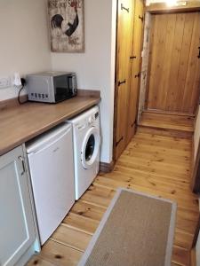 a kitchen with a washing machine and a microwave at Farm accommodation - The Lizard Peninsula, Cornwall in Helston +31 photos