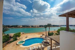 a swimming pool next to a body of water at Yasmin Villa EL Gouna in Hurghada