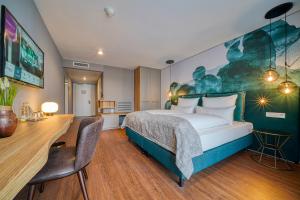 ein Hotelzimmer mit einem Bett und einem Schreibtisch in der Unterkunft FourSide Hotel Freiburg in Freiburg im Breisgau