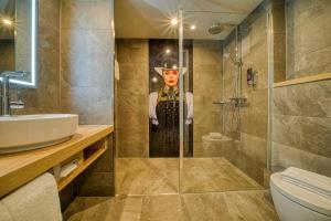 ein Badezimmer mit einer Dusche mit einem Bild eines Mannes in der Unterkunft FourSide Hotel Freiburg in Freiburg im Breisgau