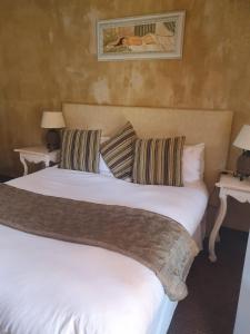 a bedroom with a large white bed with two tables at At SILVER PALMS in Tzaneen