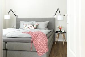 a bedroom with a bed with a pink blanket on it at Villa am Park in Binz