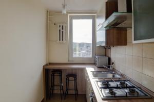 a kitchen with a stove and a sink and a window at Apartament Widokówka in Gdynia