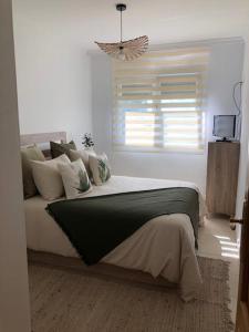 a bedroom with a bed with a window and a window at Apartamento en Boiro - Colores del Barbanza Verde in Boiro