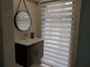 a bathroom with a sink and a mirror and a window at Hostal Doñihue in Doñihue