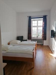 1 dormitorio con 2 camas y ventana en Kloster Langwaden, en Grevenbroich